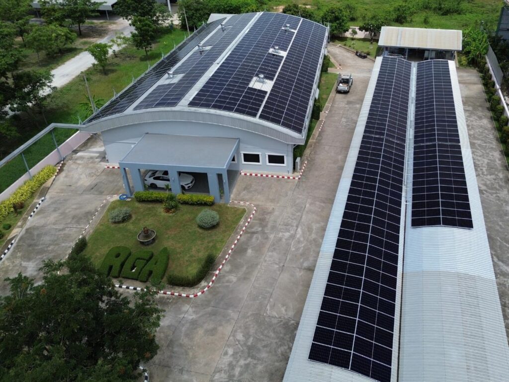 Aerial view of the RGA Diamond Co. factory in Lamphun, Thailand, with rooftop solar panels covering the main workshop and the RGA hedge logo in the garden